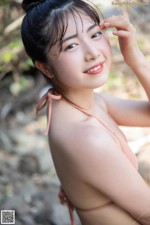 A woman in a pink bikini posing for a picture.