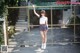 A young woman standing in front of a metal fence.