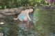 A woman in a blue and white striped bikini standing in the water.