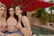 A group of three women sitting next to a swimming pool.