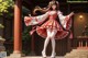 A woman in a red and white dress standing on a porch.